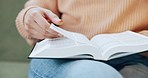 Woman, reading and hand in bible study of Christian religion in living room, home and learning about spiritual knowledge. Gospel, education and research of holy scripture of God, Jesus or faith