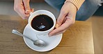 Hands of woman with coffee on table from above, relax in living room and morning beverage in home. Espresso culture, drink and girl on sofa in lounge holding cup, lunch break and rest in apartment.