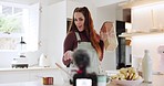 Live streaming, woman and baking for a video in the kitchen for a cooking tutorial on the internet. House, baker or a female influencer or chef speaking about food for a broadcast or online blog