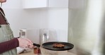 Cooking, kitchen and woman frying pancakes in a pan for a flip trick on a stove of her home. Baking, dessert and female person or chef preparing chocolate crepes for a sweet breakfast meal or snack.