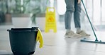 Cleaning, bucket and person with mop in office for cleaner service, professional janitor and maintenance. Manual labor, wet sign and worker for hygiene, disinfection and washing floor in workplace