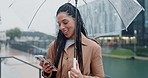 Phone, social media and woman in rain in a city typing in search of outdoor location on internet or app gps in morning. Winter, umbrella and person on vacation or holiday and chatting with connection