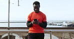 Outdoor, exercise and black man with a cellphone, smile and typing with connection, meme and digital app. City, African person or athlete with a smartphone, mobile user and social media with wellness