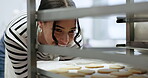 Bakery, happy woman and kitchen with cookies in oven for business, customer and breakfast in restaurant or diner. Cooking, professional baker and cake for dessert, lunch or eating with smile in cafe