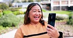 Phone, video call and smile with a mature asian woman outdoor for communication during travel or vacation. Mobile, social media or selfie app with a happy person in a park or garden during summer