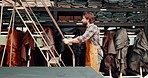 Fabric, boutique and man in workshop with ladder for textile, material and clothing on tailor shop shelf. Small business, startup and person in creative studio for clothes, industry or fashion design