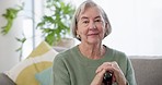 Happy, face and a senior woman in a house for peace, relax and on the living room sofa. Smile, home couch and portrait of an elderly person with a walking stick or cane for support in retirement