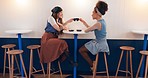 Friends, women and toast at coffee shop, drink tea cup and bonding together. Girls, smile and people cheers at cafe, restaurant table and social communication, happy and having fun at cafeteria store