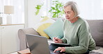 Laptop, writing and documents for investment with an old woman in the living room for retirement planning. Computer, accounting and finance for pension with a senior adult on a sofa in her home