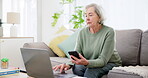 Senior woman, laptop and phone on sofa for planning, investment research or asset management website at home. Elderly person typing on mobile and computer for financial information or pension FAQ