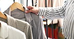 Person, hands and fashion design by clothing rack in small business, logistics or inspection at boutique. Closeup of entrepreneur or retail store owner checking fabric, material or suits at shop