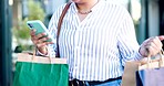 Woman, phone and hands walking with shopping bag in city for communication or travel in networking. Closeup of female person or shopper typing, texting or chatting on mobile smartphone app in town