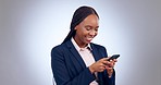 Business woman, smartphone and typing in studio for social network, funny mobile chat and media contact. Happy african worker laugh with cellphone, reading news app and information on grey background