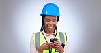 Woman, construction and engineering with phone in studio for project management, reading industrial update or planning on grey background. Happy african architect, contractor and typing on smartphone