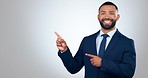 Pointing, face and businessman in a studio with mockup for marketing, promotion or advertising. Smile, happy and portrait of male lawyer from Mexico with hand gesture for mock up by white background.