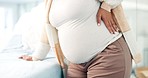 Pregnant, back pain and stomach of woman in hospital for consulting, labour and healthcare. Pregnancy, maternity and medical with closeup of person at gynecology exam for birth, tired or contractions