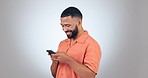 Phone, comic and man in studio with social media, streaming or laugh at funny text on grey background. Smartphone, app and guy model laughing at online comedy, joke or silly gif or chat communication