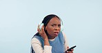 What, hear and face of black woman with headphones in studio for talking, speaking and speech. Communication, disturb and portrait of person on phone listen to music, song or audio on blue background