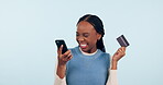 Woman winner, credit card and phone for online shopping, e commerce celebration or payment success in studio. Excited African person on mobile banking, loan news or dance for bonus on blue background