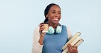 Student woman, dancing and books in studio, excited or listen to music for study by blue background. African girl, coffee cup and headphones for audio streaming subscription with notebook for college