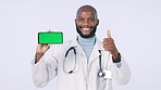 Green screen, phone and doctor with thumbs up in studio with mockup space for advertising or marketing. Happy, tracking markers and face of black man medical worker with cellphone by white background