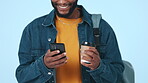 Black man, smartphone and coffee with student and chat, communication and social media on blue background. Funny meme, warm drink and using phone, college results online with mobile app in studio