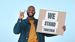Poster, solidarity and rock on with a black man on a blue background for support, unity or inclusion. Portrait, smile and devil horns with a young person at a protest, rally or march for freedom