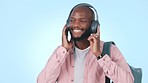 Smile, dance and black man with headphones, streaming music and student on a blue studio background. African, model and happy guy with headset, energy and wellness with radio, online audio and sound