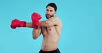 Boxing, arm stretching and man face with muscle, fitness and workout of a boxer in studio. Breathing, break and male athlete with blue background and exercise ready to start training for competition