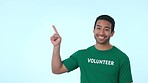 Mock up, pointing and face of volunteer in studio for marketing, promotion or advertising. Choice, options and portrait of Indian man charity worker with approval hand gesture by white background.