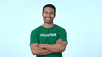 Volunteer, laughing and portrait of a man in studio for community service, help and welfare. Arms crossed, funny asian model person and volunteering for project, social care and support of charity
