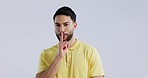 Secret, man and face with finger on lips in studio for sign of privacy on white background. Portrait, indian model and quiet for gossip, whisper and trust of emoji, mystery sale and confidential news