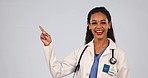 Medical doctor, pointing finger and a woman in studio with mockup space, advertising and good review. Portrait of happy female healthcare worker on grey background for announcement, medicine and hand