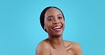 Skincare, beauty and black woman face with laughing, smile and dermatology in studio. Blue background, happy African female person and skin glow with cosmetics and makeup with wellness and shine