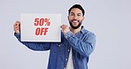 Portrait of happy man with sign for discount or sale and half price promo isolated on white background. Smile, deal and model with presentation, announcement or poster with news on offer in studio.