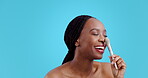 Nose, makeup and brush with face of black woman in studio for cosmetics, tools and product. Foundation, salon and powder with person on blue background for skincare, beauty treatment and dermatology