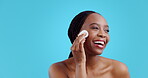 African woman, cotton and skincare in studio, cleaning or happy with thinking by blue background. Girl, model or smile with pad for natural beauty, glow or cosmetic change with self care for wellness