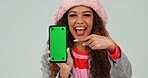 Green screen, phone and woman pointing at mobile app as hand gesture for review isolated in studio white background. Promotion, deal and young person with showing yes, like and ok symbol for website