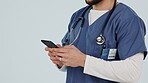Doctor, man and hands with phone in studio for online contact, reading healthcare notification and telehealth on white background. Closeup of surgeon typing on smartphone, search digital app and tech