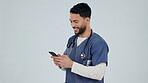 Doctor, man and smile with phone in studio for online contact, reading healthcare notification and telehealth on white background. Happy arab surgeon typing on smartphone, search digital app and tech