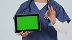 Nurse, tablet green screen and okay hands for success, healthcare services and presentation in studio. Doctor or medical person on clinic app, digital mockup and tracking marker on a white background