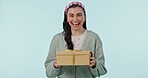 Surprise gift, box and face of woman in studio with package, competition prize and winner on blue background. Portrait of happy model, present and excited to celebrate birthday, giveaway or promotion