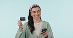 Portrait, phone and credit card with a woman customer in studio on a blue background for bank payment. Fintech, ecommerce or online shopping with a happy young person using a mobile for retail