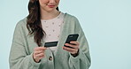 Hands, phone and credit card with a woman customer in studio on a blue background for bank payment. Fintech, ecommerce or online shopping with a person using a mobile for retail or accounting