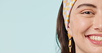 Half face, space and smile with a woman closeup on a blue background for marketing in studio. Portrait, mockup and a happy young person on a blank or empty banner for wellness advertising in studio