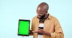 Man, tablet mock up and green screen in studio with website, internet and social network. Happy black person with technology tracking markers, advertising or app announcement on blue background