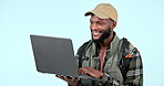 Laptop, hiking and a black man online shopping on a blue background in studio for a camping hobby. Computer, internet or research with a happy young hiker looking for directions to a location