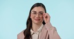 Wink, flirt and face of woman with glasses in studio with confidence, good mood or gesture on blue background. Nerd, portrait and female model with eyeglasses, goofy or silly expression with emoji