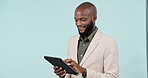 Tablet, smile and research with a business black man in studio on a blue background for networking. Technology, research or email with a happy young employee scrolling online for information