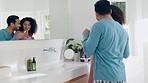 Love, hygiene and couple brushing teeth in the bathroom together on a weekend morning routine. Happy, hug and young man and woman doing treatment for dental health or oral care at modern apartment.